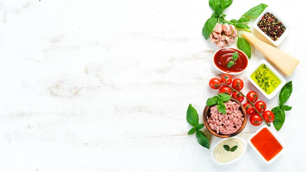 Preparing Bolognese sauce. On a white wooden background. Top view. Free space for your text.