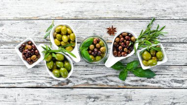 Beyaz ahşap bir arka planda zeytin seti. Üst görünüm. Metniniz için boş alan.
