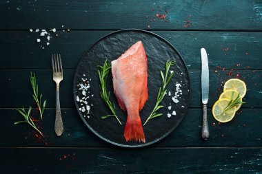 Limon ve biberiye ile balık çiğ Snapper. Siyah bir arka planda. Üst görünüm. Metniniz için boş alan.