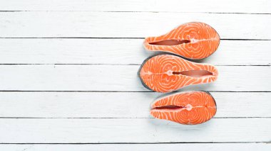 Beyaz arka planda malzemeler ile taze somon biftek ahşap. Üst görünüm. Metniniz için boş alan.