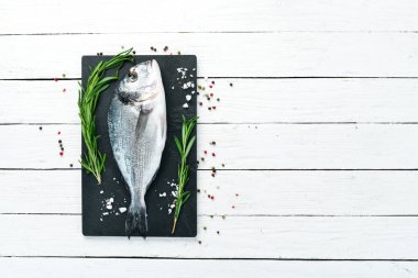 Beyaz bir arka plan üzerinde limon ve baharat ile çiğ balık. Balık doradosu. Üst te. Metniniz için boş alan.