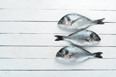 Beyaz bir arka plan üzerinde limon ve baharat ile çiğ balık. Balık doradosu. Üst te. Metniniz için boş alan.