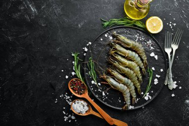 Çiğ, limonlu kaplan karidesi. Deniz ürünleri. Üst Manzara. Siyah bir arka planda. Boş kopyalama alanı.