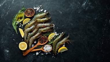 Çiğ, limonlu kaplan karidesi. Deniz ürünleri. Üst Manzara. Siyah bir arka planda. Boş kopyalama alanı.