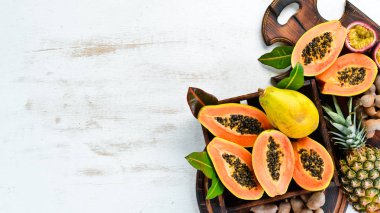 Beyaz ahşap arka plan üzerinde tatlı olgun taze papaya. Üst te. Metin için boş alan.