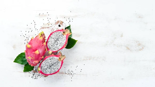 Fruit dragon on a white wooden background. Pitahaya Tropical Fruits. Top view. Free space for text.