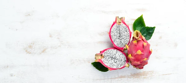 Fruit dragon on a white wooden background. Pitahaya Tropical Fruits. Top view. Free space for text.