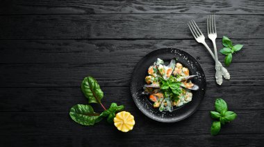 Fesleğenli krema soslu midyeler. Eski arka planda. Üst te. Ücretsiz kopyalama alanı.