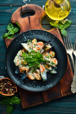 Fesleğenli krema soslu midyeler. Eski arka planda. Üst te. Ücretsiz kopyalama alanı.