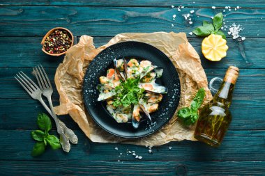 Fesleğenli krema soslu midyeler. Eski arka planda. Üst te. Ücretsiz kopyalama alanı.