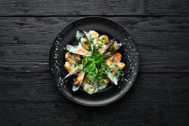 Fesleğenli krema soslu midyeler. Eski arka planda. Üst te. Ücretsiz kopyalama alanı.