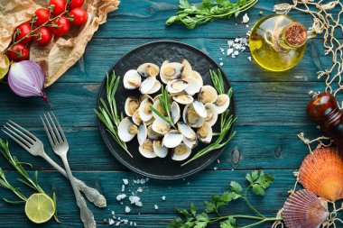 Bir tabakta baharat ile haşlanmış istiridye. Siyah arka planda deniz ürünleri. Üst te. Ücretsiz kopyalama alanı.