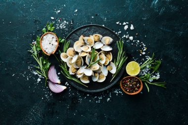 Bir tabakta baharat ile haşlanmış istiridye. Siyah arka planda deniz ürünleri. Üst te. Ücretsiz kopyalama alanı.