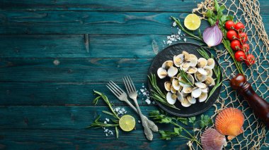 Bir tabakta baharat ile haşlanmış istiridye. Siyah arka planda deniz ürünleri. Üst te. Ücretsiz kopyalama alanı.