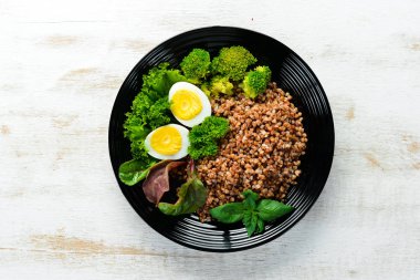 Yumurta ve brokoli ile haşlanmış karabuğday. Yemekler menüsü. Ücretsiz kopya alanı. Üstte görüntü.
