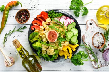 Domates, incir ve taze sebze ile Makarna. Buda kase tarifi. Yemekler menüsü. Ücretsiz kopya alanı. Üstte görüntü.