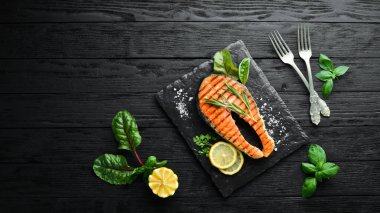 Taş tabakta ızgara somon bifteği. Eski bir arka planda. Üst te. Ücretsiz kopyalama alanı.