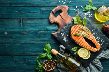 Taş tabakta ızgara somon bifteği. Eski bir arka planda. Üst te. Ücretsiz kopyalama alanı.