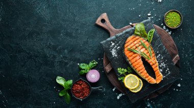 Taş tabakta ızgara somon bifteği. Eski bir arka planda. Üst te. Ücretsiz kopyalama alanı.