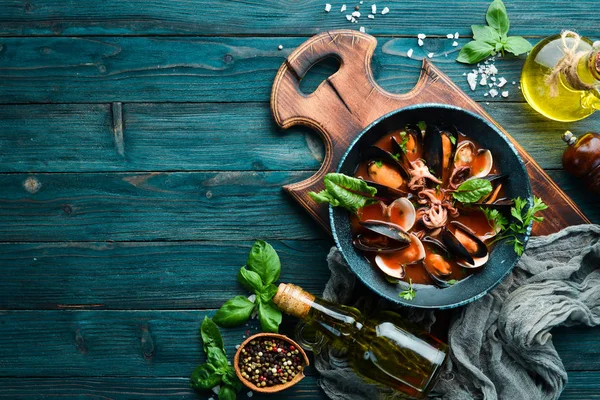 Deniz mahsullü domates çorbası. Midye, istiridye ve ahtapot. Eski arka planda. Üst te. Ücretsiz kopyalama alanı.