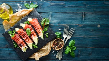 Prosciutto bir taş plaka üzerinde kavun ile. Geleneksel İtalyan mezesi. Üst te. Ücretsiz kopyalama alanı.