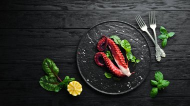 Taş tabakta haşlanmış ahtapot dokunaçları. Deniz ürünleri. Üst te. Ücretsiz kopyalama alanı.