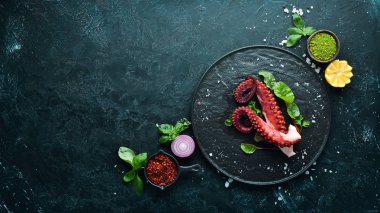 Taş tabakta haşlanmış ahtapot dokunaçları. Deniz ürünleri. Üst te. Ücretsiz kopyalama alanı.