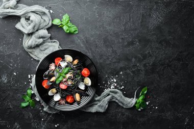 Deniz ürünleri ile makarna. Siyah macun. Deniz ürünleri. Üst te. Ücretsiz kopyalama alanı.