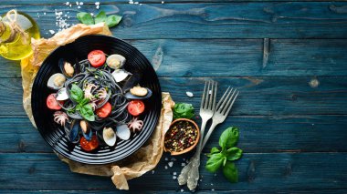 Deniz ürünleri ile makarna. Siyah macun. Deniz ürünleri. Üst te. Ücretsiz kopyalama alanı.