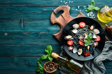 Deniz ürünleri ile makarna. Siyah macun. Deniz ürünleri. Üst te. Ücretsiz kopyalama alanı.