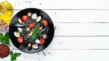 Deniz ürünleri ile makarna. Siyah macun. Deniz ürünleri. Üst te. Ücretsiz kopyalama alanı.