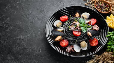 Deniz ürünleri ile makarna. Siyah macun. Deniz ürünleri. Üst te. Ücretsiz kopyalama alanı.