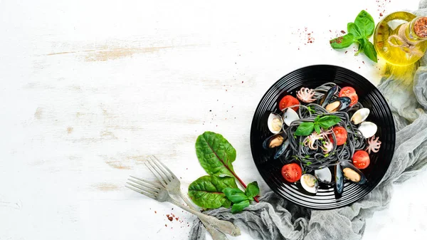 Deniz ürünleri ile makarna. Siyah macun. Deniz ürünleri. Üst te. Ücretsiz kopyalama alanı.