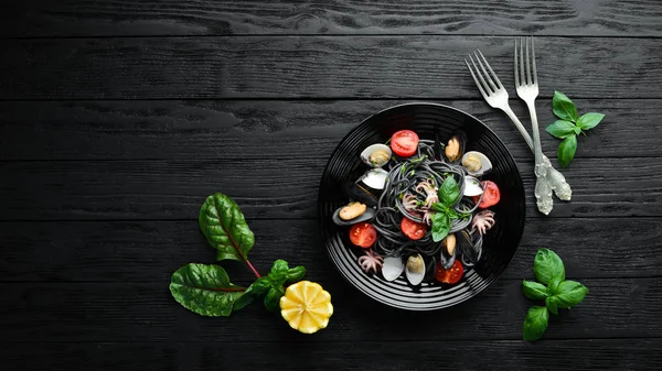 Deniz ürünleri ile makarna. Siyah macun. Deniz ürünleri. Üst te. Ücretsiz kopyalama alanı.