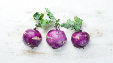 Ahşap arka plan üzerinde yeşil yaprakları ile Kohlrabi lahana. Üst te. Metniniz için boş alan.