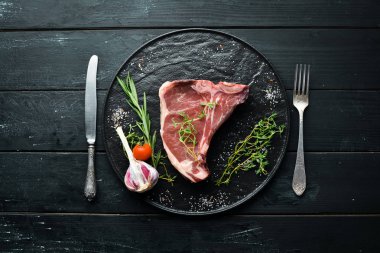 Tahta bir masada çiğ t-kemik biftek. Üst te. Metin için boş alan.