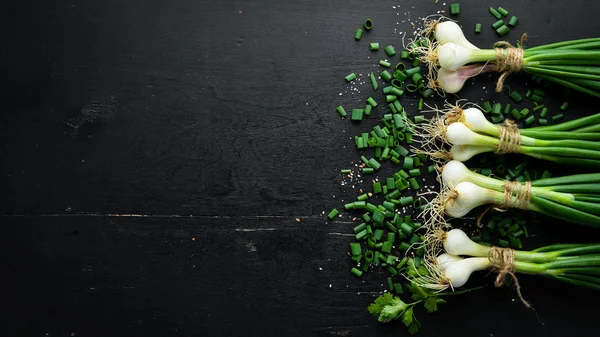 Tahta bir masada yeşil soğan. Taze sebzeler. Üst te. Metin için boş alan.