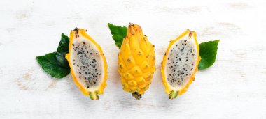 Beyaz ahşap arka plan üzerinde Sarı Ejderha Meyve. Pitahaya Tropikal Meyveler. Üst te. Metin için boş alan.