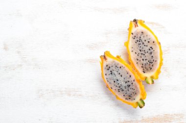 Beyaz ahşap arka plan üzerinde Sarı Ejderha Meyve. Pitahaya Tropikal Meyveler. Üst te. Metin için boş alan.