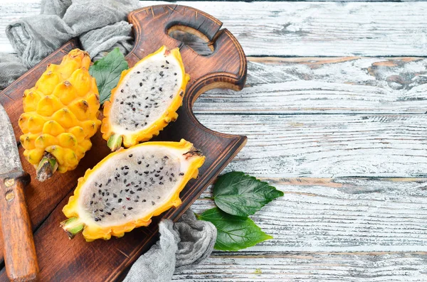 Beyaz ahşap arka plan üzerinde Sarı Ejderha Meyve. Pitahaya Tropikal Meyveler. Üst te. Metin için boş alan.