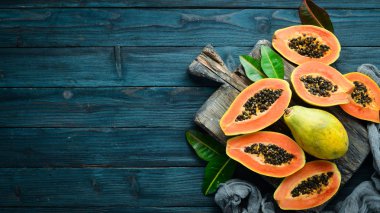 Tropikal meyveler, tatlı papaya, mavi ahşap arka plan üzerinde çiğ vegan gıda. Üst te. Metin için boş alan.