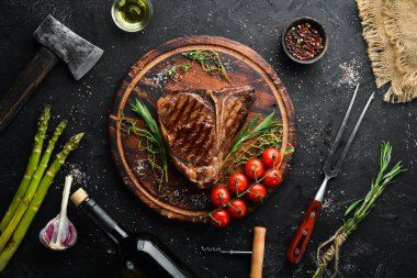 Grilled Steak on a stone table. Top view. Free space for text. clipart