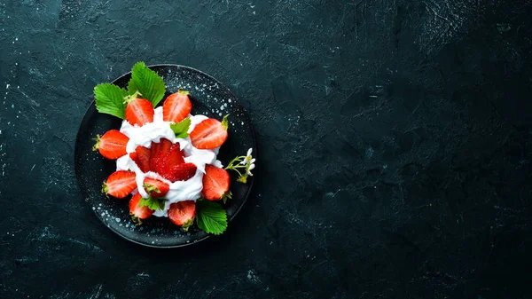 Bir tabakta krema ile Çilek. Tatlı. Çilek Üst görünüm. Metniniz için boş alan.