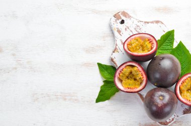 Beyaz ahşap arka plan üzerinde bir yaprak ile Passion meyve. Tropikal Meyveler. Üst te. Metin için boş alan.