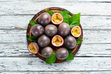 Beyaz ahşap arka plan üzerinde bir yaprak ile Passion meyve. Tropikal Meyveler. Üst te. Metin için boş alan.