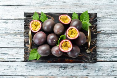 Beyaz ahşap arka plan üzerinde bir yaprak ile Passion meyve. Tropikal Meyveler. Üst te. Metin için boş alan.