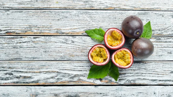 Beyaz ahşap arka plan üzerinde bir yaprak ile Passion meyve. Tropikal Meyveler. Üst te. Metin için boş alan.