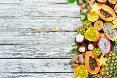 Beyaz arka planda tropikal meyveler: papaya, mangosten, kaktüs meyvesi, piraya, ananas. Üst te. Metin için boş alan.