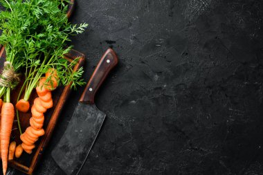 Siyah taş arka planda taze havuç. Üst görünüm. Metniniz için boş alan.