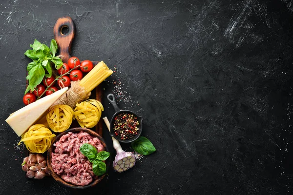 Makarna Bolonez için Malzemeler. Siyah bir arka plan üzerinde. Üst te. Metniniz için boş alan.